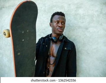 Cool Isolated Portrait Of Young Attractive And Confident Hipster Black Afro American Man Leaning On Street Wall Holding Skate Board As Badass Guy In Urban Style Concept