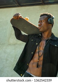 Cool Isolated Portrait Of Young Attractive And Confident Hipster Black Afro American Man Walking On Street Holding Skate Board Looking A Badass Guy In Urban Style Concept