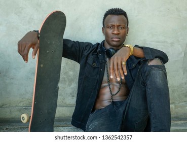 Cool Isolated Portrait Of Young Attractive And Confident Hipster Black Afro American Man Leaning On Street Wall Holding Skate Board As Badass Guy In Urban Style Concept