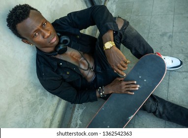 Cool Isolated Portrait Of Young Attractive And Confident Hipster Black Afro American Man Leaning On Street Wall Holding Skate Board As Badass Guy In Urban Style Concept