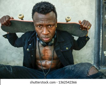 Cool Isolated Portrait Of Young Attractive And Confident Hipster Black Afro American Man Leaning On Street Wall Holding Skate Board As Badass Guy In Urban Style Concept