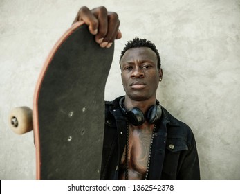 Cool Isolated Portrait Of Young Attractive And Confident Hipster Black Afro American Man Leaning On Street Wall Holding Skate Board As Badass Guy In Urban Style Concept