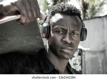 Cool Isolated Portrait Of Young Attractive And Confident Hipster Black Afro American Man Walking On Street Holding Skate Board Looking A Badass Guy In Urban Style Concept