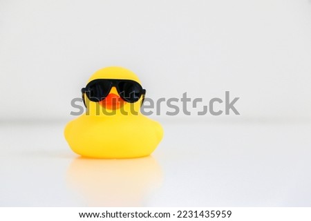 Cool little yellow rubber duck wearing black sunglasses, copy space on the right. Be smart, be cool concept.