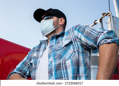 Cool Looking Truck Driver Dressed In Casual Clothing With Plaid Shirt And Black Baseball Cap Wears Protective Medical Face Mask. Measures Taken In Transportation Industry To Protect Against Coronvirus