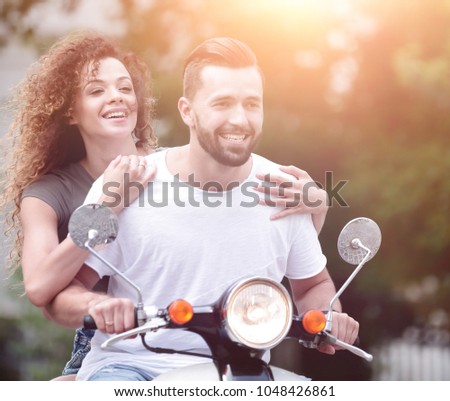 Cool man and beautiful girl riding on  scooter with  expression