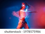 Cool mixed race young girl moving in colourful studio light. Long exposure. Contemporary stylish advertising photo