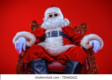 Cool modern Santa Claus in sunglasses over red background. Christmas concept. 