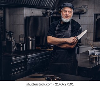 Cool Old Man Chef Holding Knife In Modern Kitchen