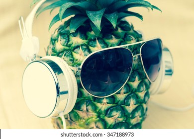 Cool pineapple with sunglasses and headphones in summer themed photo