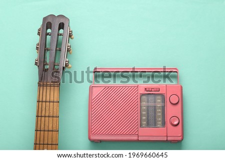 Cool pink radio and guitar neck on mint green background. Music concept. Flat lay