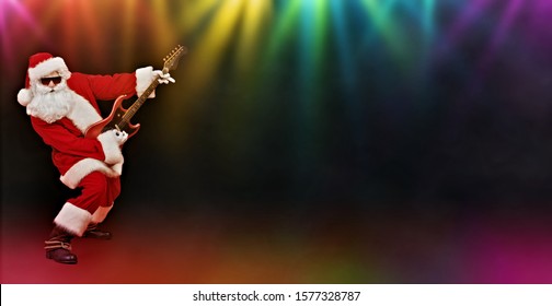 Cool Santa Claus rock musician with electric guitar and in sunglasses  in the rays of multi-colored lamps. Christmas and New Year party.  - Powered by Shutterstock