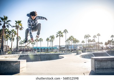 Cool skateboarder outdoors - Afroamerican guy jumping with his skate and performing a trick - Powered by Shutterstock