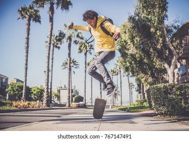 Cool skateboarder outdoors - Afroamerican guy jumping with his skate and performing a trick - Powered by Shutterstock