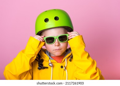 Cool Stylish Kid Boy In Sunglasses And Helmet Look In Camera Isolated On Pink. Funny Child Boy In Yellow Bright Clothes Ready To Do Sport