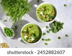 Cool Summer Pea Soup with Croutons, Sour Cream, Fresh Mint, Pea Sprouts, and Parsley Green Oil. Vegetarian Cuisine Idea. Artisanal Photography, Not AI