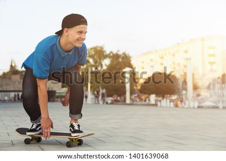 Cool Teen Skater Riding On Skateboard in Urban Area, Summer Evening, empty space