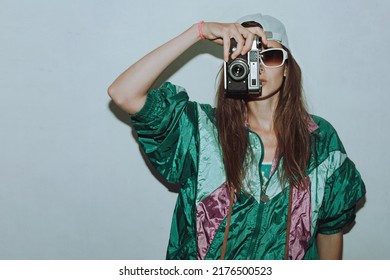 Cool teenager. Fashionable girl in colorful trendy jacket and vintage retro sunglasses with camera film in 80s - 90s style. Teenage girl at the disco, on a white background. - Powered by Shutterstock