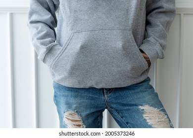 Cool Woman In A Gray Hoodie With A Ripped Jeans