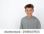 cool young 12 year old boy with grey hoody sweater posing in front of white background, having fun