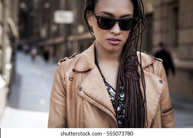 Cool young African woman wearing sunglasses on the street.