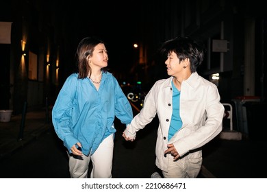 Cool Young Asian Couple Walking In The City Of Madrid At Night And Having Fun.