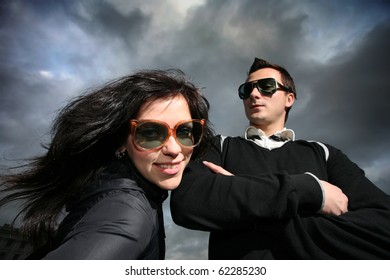 Cool young couple over dramatic cloudy sky