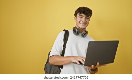 Cool young hispanic teenager enjoying life, smiling confidently with laptop  headphones. casual student guy sporting a backpack, isolated against a vibrant yellow wall. - Powered by Shutterstock