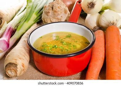 Cooled Vegetable Stock In A Red Enamel Pot