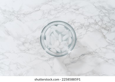 Cooling hard-boiled eggs in a glass bowl with cold water and ice cubes. - Shutterstock ID 2258588591