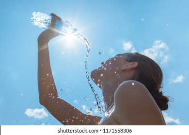 Cooling Off In The Summer Heat. Female Runner Splashing Bottle Of Water On Face.