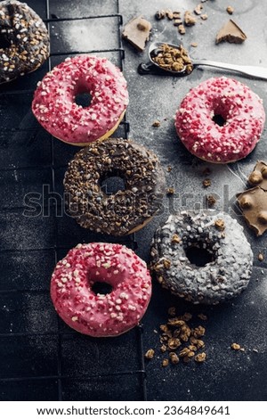 Cooling rack with delicious donuts on dark background