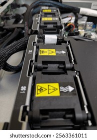 Cooling system inside a PC server with multiple fans, each marked with yellow warning labels for electrical hazards and airflow direction.