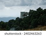 Cooling tower of nuclear power plant with cloudy sky in the background. Nuclear power station An industry tower in forest clouds of smoke from the ground Clean energy for cop-28