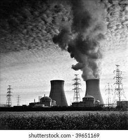 cooling towers of a nuclear power plant creating dark clouds monochrome film grain