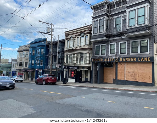 Cooper Alley\
and Barber bar boarded up with car driving by - Marina District,\
San Francisco, CA, March 21,\
2020