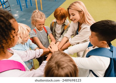 Cooperation in small group of schoolchildren. Team spirit at school between pupils young mixed race students standing in round ring together - Powered by Shutterstock