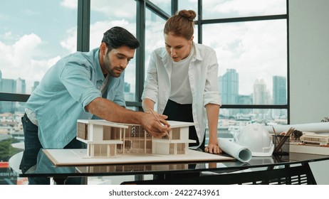 Cooperative architect engineer team working together to measure house model by using pencil. Successful caucasian interior designer team inspect architectural model construction. Design. Tracery - Powered by Shutterstock