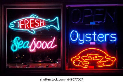 COOS BAY, OREGON, UNITED STATES - September 2, 2009: Restaurant window filled with a variety of seafood neon signs at night