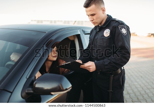 Cop in uniform\
checks license of female\
driver