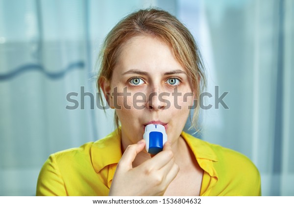 COPD or chronic obstructive pulmonary disease\
treatment with bronchodilator powder inhaler. A young woman uses\
dispenser with powders inhalation to relieve symptoms of asthma,\
and breathing relief.