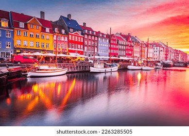 Copenhage, Denmark. Experience the breathtaking beauty of Nyhavn canal at sunrise, with its iconic colorful buildings and serene water reflections.