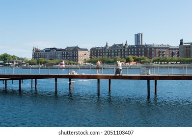 Copenhagen, Denmark - 02 Sep 2021: Young People Sunbathing In The City Centre And Old Couple Walking, At Kalvebod Wave, Kalvebod Brygge