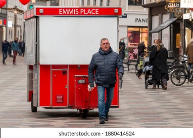 Copenhagen, Denmark - 12 Dec 2020: A Man Walking With A Traditional Hot Dog Cart In The City Centre.