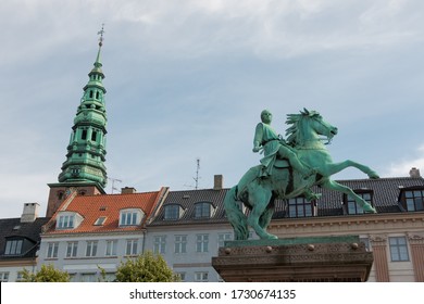 Copenhagen, Denmark - August 22, 2019: Equestrian Statue Of Bishop Absalon On Højbro Plads And Nikolaj Kunsthall Bell Tower In The Background In Copenhagen