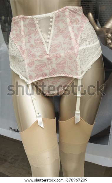 COPENHAGEN, DENMARK - CIRCA JUNE 2016: Aubade\
white and pink suspender belt with four straps and nude stockings\
worn by a mannequin in a shop\
window