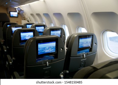 COPENHAGEN, DENMARK - NOV 24th, 2018: Empty Airplane Seats Waiting For Passengers And Take Off In An Airplane. Empty Plane Interior Before Flight And Departure. Watching Movie On An Aircraft