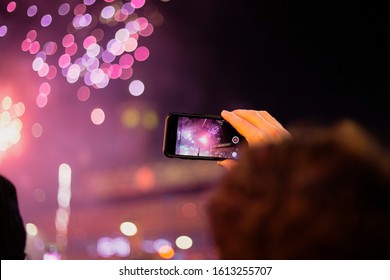 Copenhagen, Zealand / Denmark - 1 1 January: A Young Man Is Holding An Iphone 8 And Filming The New Year Fireworks By The Copenhagen City Hall. Bokeh Background. 