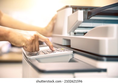 Copier printer, Close up hand office man press copy button on panel to using the copier or photocopier machine for scanning document printing a sheet paper and xerox photocopy. - Shutterstock ID 2102621596