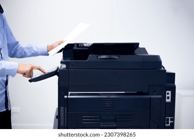 Copier printer, Close up hand office man press copy button on panel to using the copier or photocopier machine for scanning document printing a sheet paper.